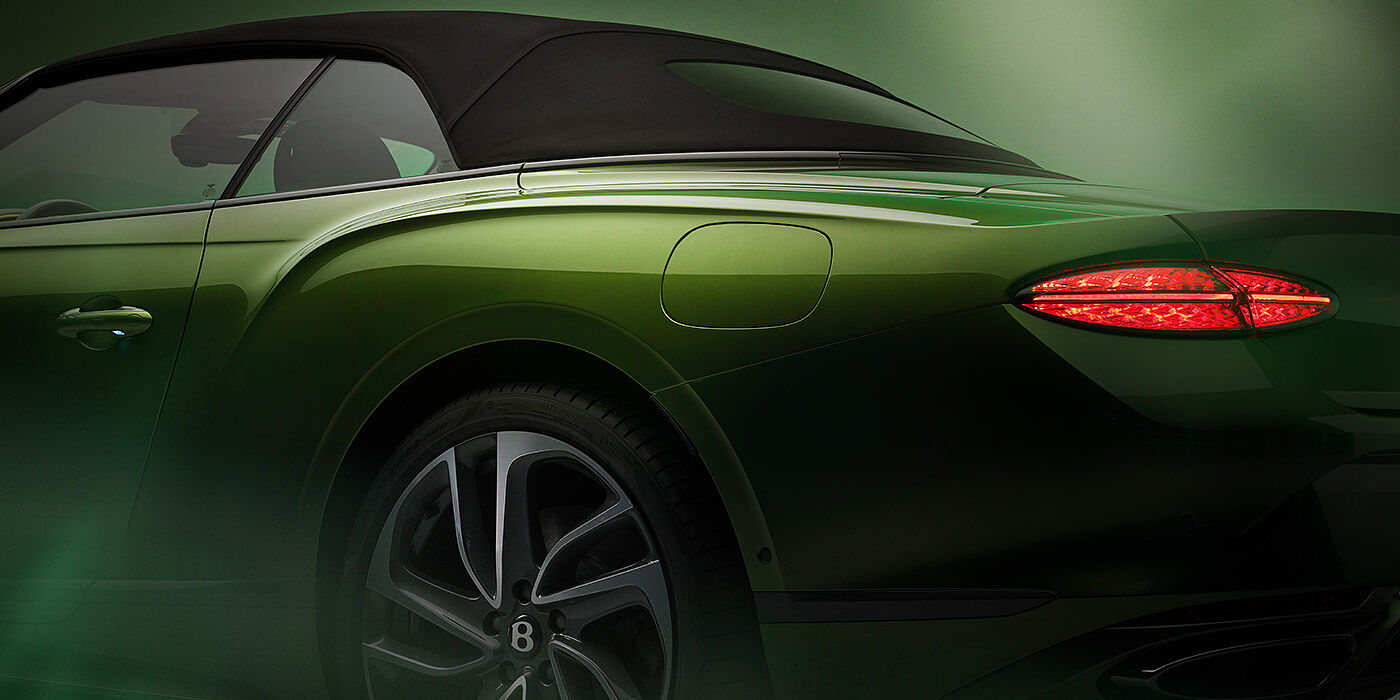 Bentley Almaty Bentley New Continental GTC Speed rear haunch and tail lamp in Tourmaline Green paint and dark tint brightware with black hood up and illuminated head lamps