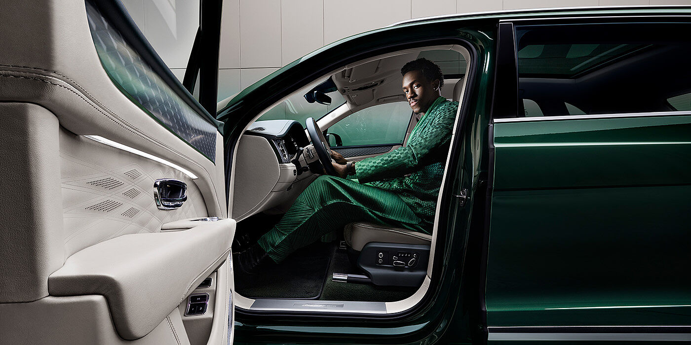 Bentley Almaty Wisdom K seated in Bentley Bentayga Extended Wheelbase SUV in Light Emerald green paint with door open