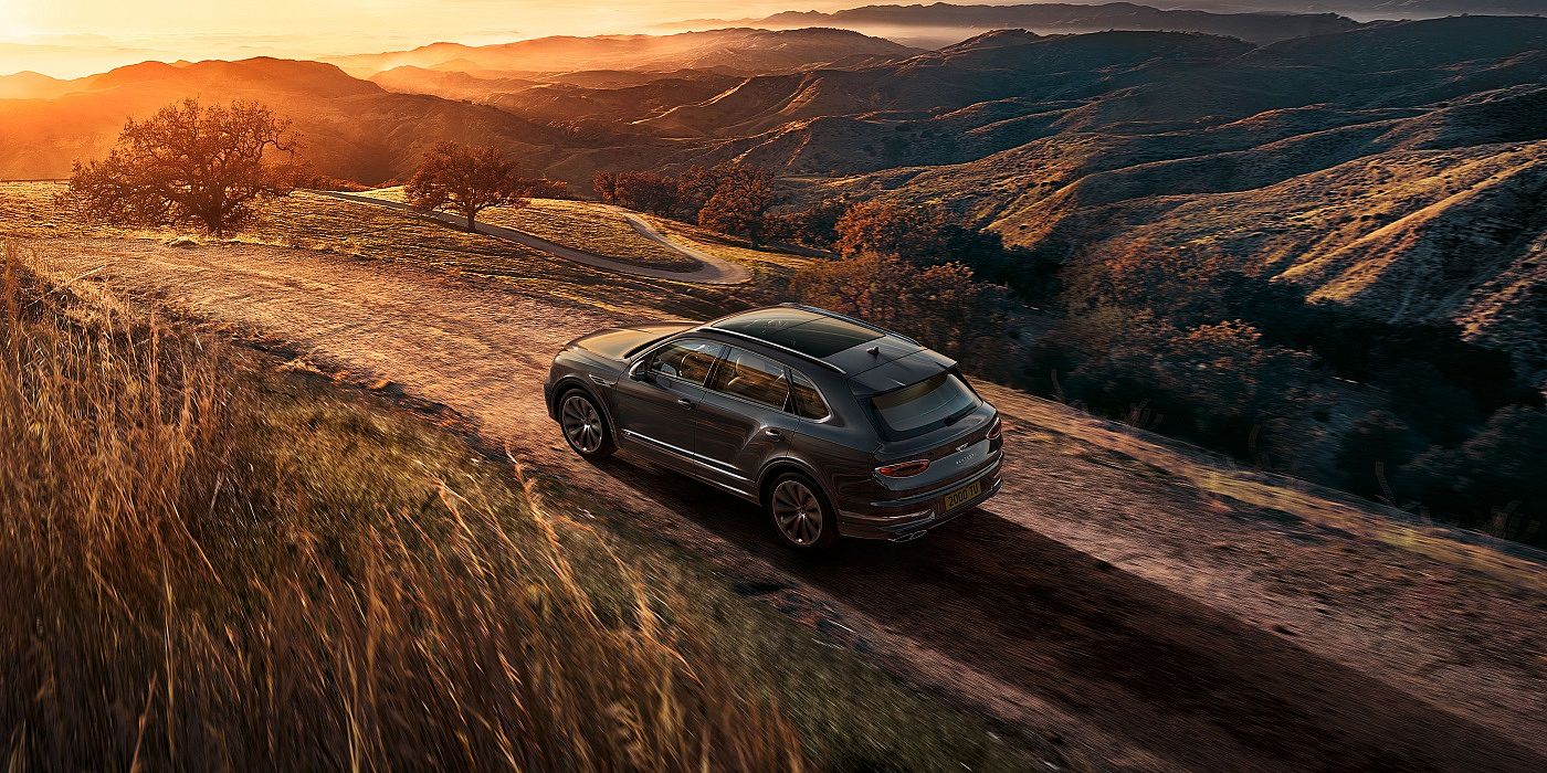 new-bentley-bentayga-v8-driving-on-dirt-road-at-sunset-in-hallmark-paint-2020