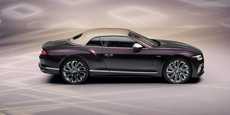 Bentley Almaty Bentley Continental GTC Mulliner convertible in profile with hood up, in Tanzanite Purple paint and 22 inch Mulliner painted and polished wheels
